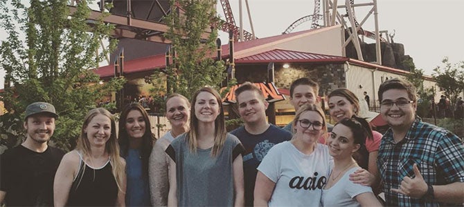 Nu Skin staff pose for a picture in front of the Cannibal roller coaster at Lagoon